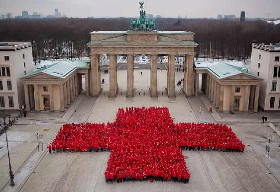 Die Mitarbeiter des DRK bilden ein riesiges Rotes Kreuz vor dem Brandenburger Tor