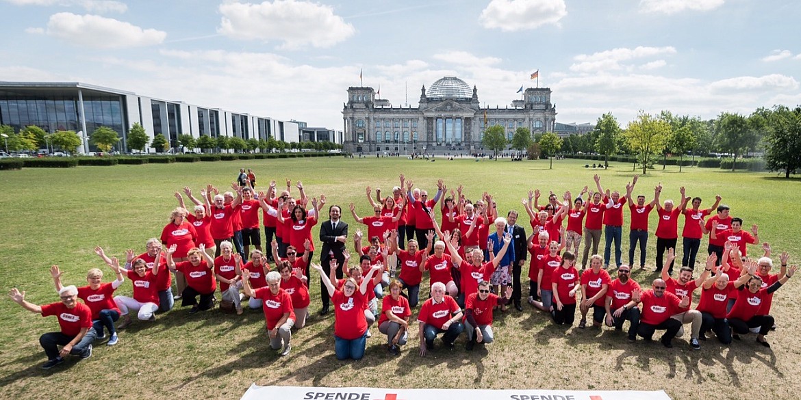 Menschen formen die Buchstaben der Blutgruppen vor dem Bundestag