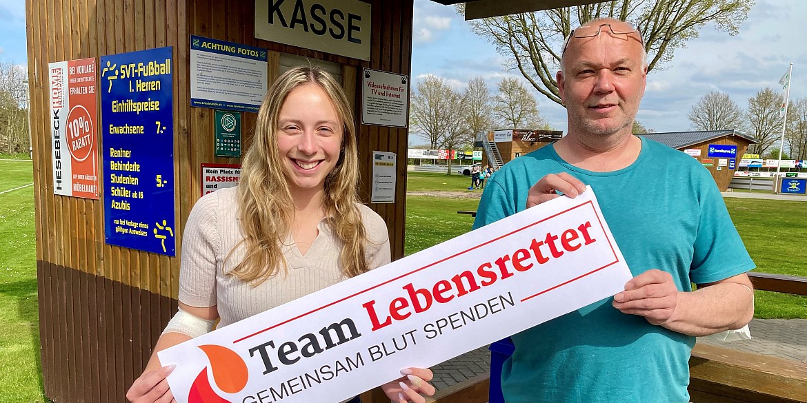 Eine Frau und ein Mann halten den Team-Lebensretter Banner