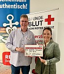 blutspende-stehen-halten whiteboard-lächeln-rewe-firmenblutspende